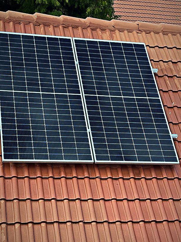 Two panel residential solar installation on terracotta tiles